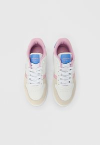 Λευκά αθλητικά παπούτσια με ροζ και μπλε λεπτομέρειες. Διαθέτουν σουέτ και δερμάτινα υλικά, στρογγυλή μύτη, κορδόνια και επένδυση στον αστράγαλο για άνεση. Εταιρικό λογότυπο Lacoste.