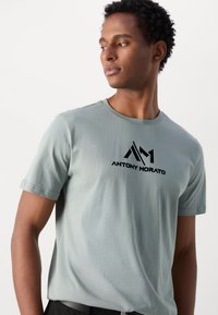 Lichtgroen T-shirt met korte mouwen, voorzien van een zwart "ANTONY MORATO" logo op de borst, gemaakt van zacht katoen met een gladde textuur.