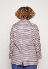 Rutigt blazer i beige, blå och vinröd, med slagkrage, långa ärmar och en ryggslits för rörlighet.