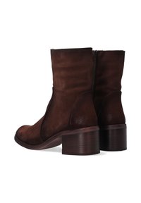 Brązowe botki zamszowe z zaokrąglonym noskiem, zapięciem na zamek z tyłu oraz masywnym, drewnianym obcasem. Gładka faktura na całej powierzchni.