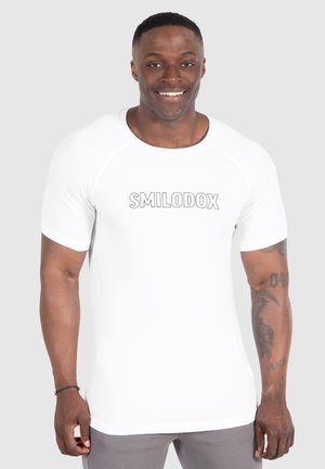 Camisa deportiva blanca de manga corta con un cuello redondo y el logo "SMILODOX" impreso en gris en la parte delantera. Tejido suave y elástico.