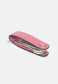 Rode leren sleutelhanger met zwarte accenten, voorzien van een metalen sleutelhanger en platte schroevendraaier, compact ontwerp, gestructureerd oppervlak.