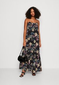 Maxi-Kleid aus schwarzem Stoff mit einem floralen Muster in Rosa-, Grün- und Blautönen; beinhaltet verstellbare Spaghetti-Träger und ein gestuftes Design.