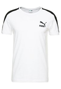 Camiseta de algodón blanca con acentos negros en los hombros. Presenta un pequeño logo negro de Puma en el pecho y un escote de tipo crew.