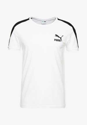 Camiseta de algodón blanca con acentos negros en los hombros. Presenta un pequeño logo negro de Puma en el pecho y un escote de tipo crew.