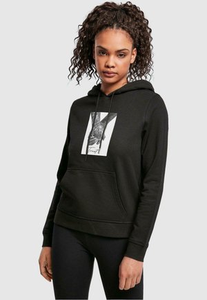 Svart hoodie med en framficka och dragsko på huvan. Har en grafik av händer på framsidan. Mjukt tyg med en avslappnad passform.