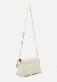 Krämfärgad läder crossbody-väska med en strukturerad form, övre klaffstängning och justerbar rem. Guldiga metalldetaljer och slät textur.