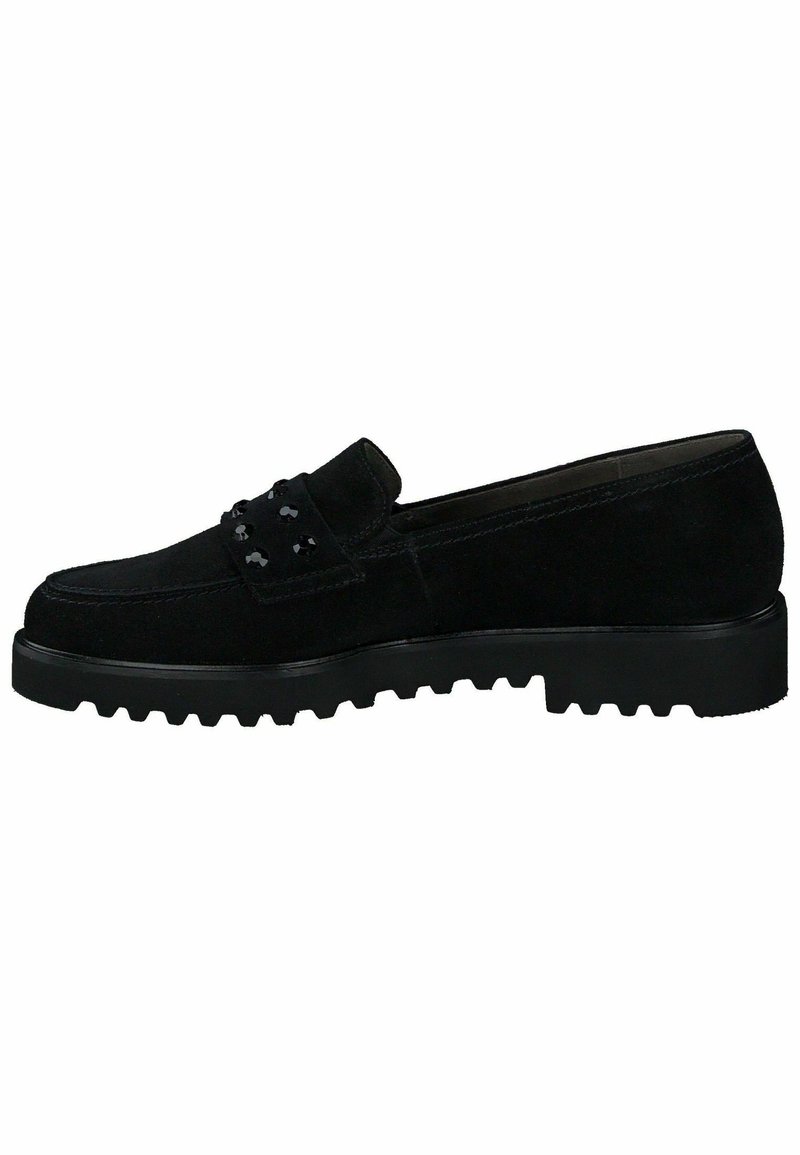 Zapato negro de ante sin cordones con puntera redondeada, tachuelas decorativas en la parte superior y suela de goma texturizada con patrones de relieve profundos.