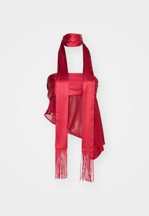 Czerwony top z satyny o marszczonym kroju, z długimi frędzlami z przodu i z tyłu, o gładkiej fakturze. Dołączone regulowane paski na szyję.