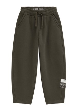Jogginghose aus olivgrünem Fleece mit elastischem Bund, Kordelzug, Seitentaschen und zwei Stoffflicken am unteren rechten Bein.