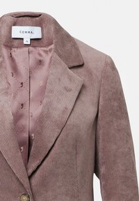 Bruine ribfluwelen blazer met een gekarteld kraag, voorzien van een lichtroze satijnen voering met subtiele patronen. Etiket toont merk- en maatinformatie.