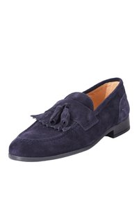 Mocassini in suede blu navy presentano una punta rotonda, nappine decorative sulla parte anteriore e un tacco nero basso. La fodera interna liscia completa il design.