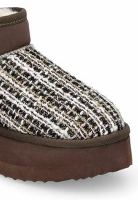 Scarpa slip-on con tomaia intrecciata nera, bianca e rosa caratterizzata da filamenti metallici e suola in gomma marrone. Fodera morbida attorno al colletto.