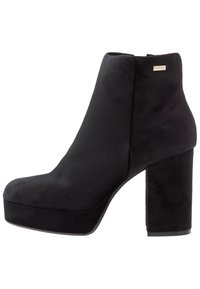 Bottines à plateforme noires avec une texture lisse rappelant le daim, bout arrondi, talon bloc haut et un petit accent logo métallique.