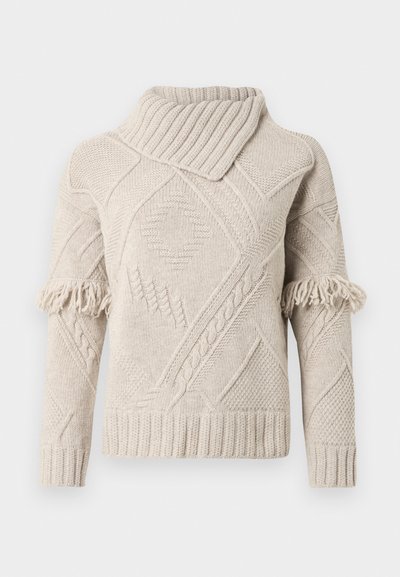 Beige neulepusero poolokauluksella, jossa geometrisiä kuvioita, punottuja yksityiskohtia ja hapsuja ylähihoissa.