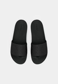 Sorte slidesandaler med en tekstureret overflade, der har et gentaget logo-mønster. Glat, mat finish på indersålen og remmen.