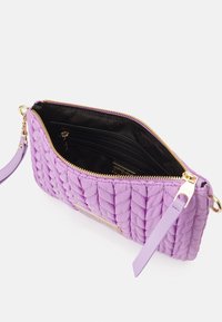 Borsa a busta trapuntata viola con zip dorata e fodera nera. Presenta una tracolla regolabile e tasche interne per un'adeguata organizzazione.