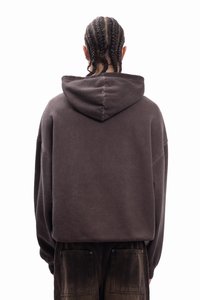 Καφέ oversized φούτερ με ραφή στην πλάτη και ρυθμιζόμενο καπαρντίνα. Φορεμένο με σκούρο καφέ παντελόνι cargo με μεγάλες τσέπες. Μαλακό, υφασμάτινο ύφασμα με υφή.