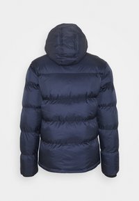 Marinblå pufferjacka med huva, som har horisontell quiltning, elastiska manschetter och en slät yta. Minimalistisk design, ingen synlig hårdvara.