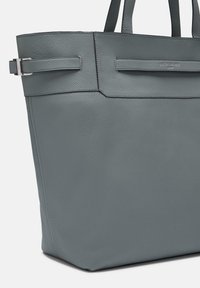 Szara skórzana torba typu tote o wyraźnej strukturze, z dwiema górnymi uchwytami i minimalistycznym wzornictwem. Zawiera subtelne metalowe akcenty i przeszycia.