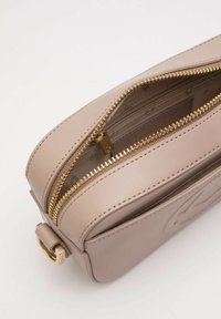 Borsa rettangolare in pelle beige chiaro con zip e dettagli in oro, caratterizzata da una superficie texture e più scomparti per la gestione degli oggetti.