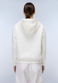 Hoodie in crèmekleurige stof, met ribbelboorden en zoom. Zachte textuur, minimalistisch ontwerp en geen zichtbare branding op de achterkant.