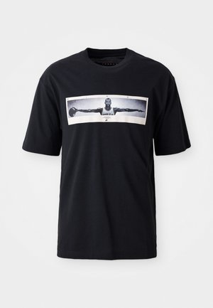 Black cotton t-shirt featuring a large graphic print of a basketball player with outstretched arms, bordered with the word “WINGS.”