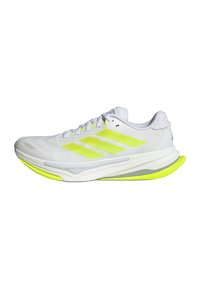 White athletic shoes with neon yellow accents, a mesh upper, three stripes logo, and a cushioned sole designed for comfort and performance.