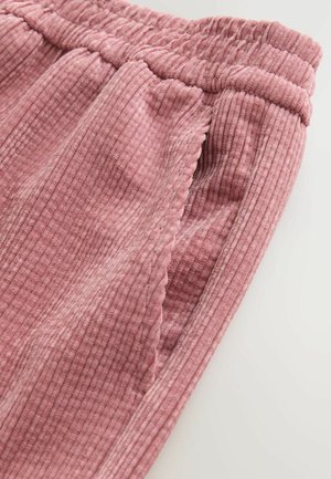 Růžové žebrované kalhoty z měkké látky s elastickým pasem a bočními kapsami. Textura je jemná a má mírné odstínové variace.