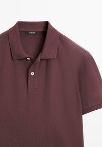 Kurzärmeliges Poloshirt in dunklem Burgunderrot mit zwei weißen Knöpfen und umgeschlagenem Kragen, gefertigt aus strukturiertem Stoff.