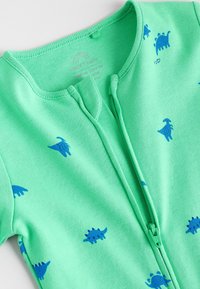 Green zip-up onesie made of soft fabric with blue dinosaur patterns, featuring a ribbed neckline and a smooth zipper closure.