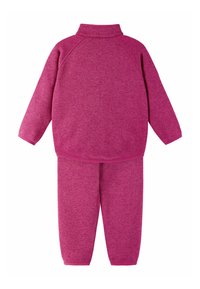 Dres z polaru w jaskrawym różowym kolorze, składający się z bluzy z półgolfem i spodni typu jogger z elastycznymi ściągaczami. Miękka, teksturowana tkanina na całej powierzchni.