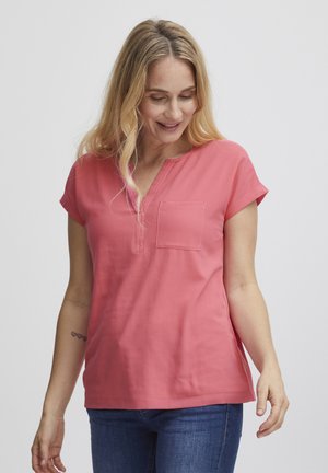 Koralfarvet t-shirt med korte ærmer, V-hals og en lomme på venstre bryst. Har en afslappet pasform og en glat bomuldsstruktur.