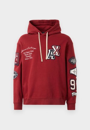 Red hoodie with a drawstring, featuring "AX" logo and various patches, including sports-themed graphics and text, crafted from soft fabric.