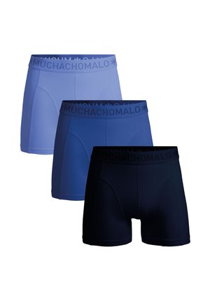Tres pares de calzoncillos tipo bóxer en azul claro, azul oscuro y azul marino, con una cinturilla elástica suave que presenta la marca "MUCHACHOMALO" y una textura lisa.