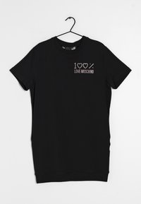 Svart kortärmad t-shirt i mjukt tyg, med "100% LOVE MOSCHINO" i rhinestones på vänster bröstområde. Hänger på en krok.