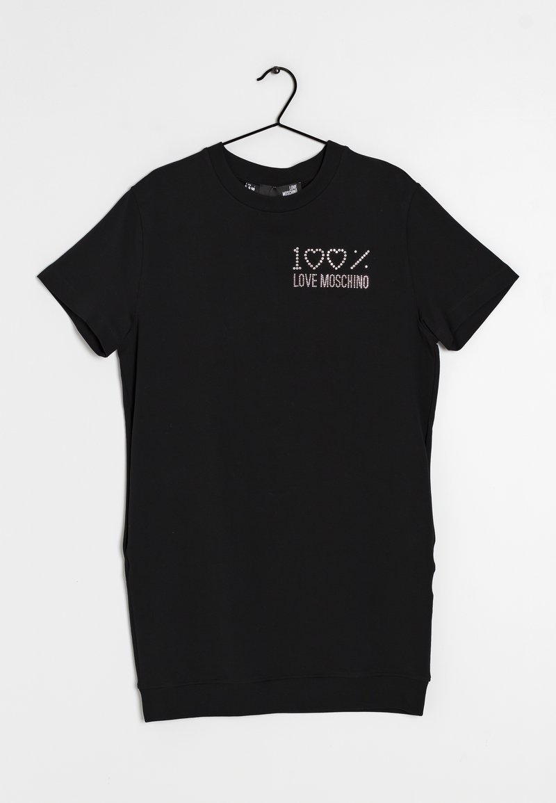 Svart kortärmad t-shirt i mjukt tyg, med "100% LOVE MOSCHINO" i rhinestones på vänster bröstområde. Hänger på en krok.