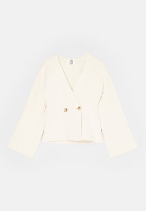 Crème-kleurige cropped wikkeljas met een diepe V-hals, lange wijde mouwen en twee gouden knoopsluitingen. Zacht, gestructureerd materiaal.