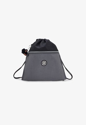 Sivutaskuinen reppu harmaasta ja mustasta nailonista, jossa on metallivetoketju ja pieni apina avaimenperä kiinnitettynä vetoketjun vetimeen.