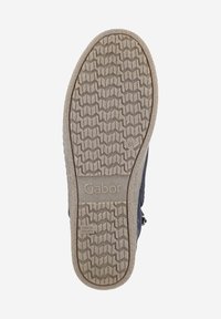 Suola della scarpa, materiale gommoso, motivo di presa testurizzato, colore beige, con logo "Gabor", leggera curvatura verso la punta.