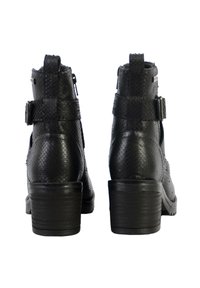 Botas de tobillo de cuero negro con acabado texturizado, puntas redondeadas, tacones gruesos y hebillas ajustables en el tobillo. Cierre de cremallera en el lateral.