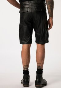 Zwarte leren cargoshorts met een lengte tot halverwege de dij, voorzien van zijzakken en knopenaccenten op de achterkant. Gladde textuur en slanke ontwerp.