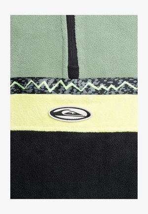 Groene fleece pullover met een rits aan de voorkant, zwarte en gele strepen, en een gestructureerd zwart grafisch patroon met een logo patch.