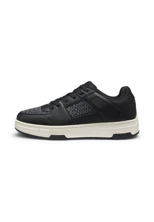 Black sneaker with a textured upper, featuring leather and fabric panels. White midsole and black outsole. Laces and logo accents visible.