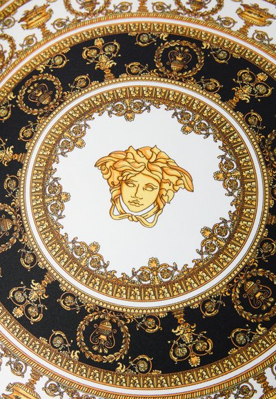 Κεφάλι της Μέδουσας στο κέντρο περίτεχνου κυκλικού σχεδίου με χρυσαφένια και μαύρα μπαρόκ ανθικά και αγγειακά μοτίβα σε λευκό φόντο.