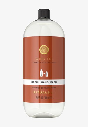 Klare Plastikflasche mit orangefarbenem Etikett und schwarzem Verschluss. Das Etikett trägt die Aufschrift "Wild Fig Nachfüll-Handseife" und zeigt Kapazität sowie Nachfüllsymbol an.