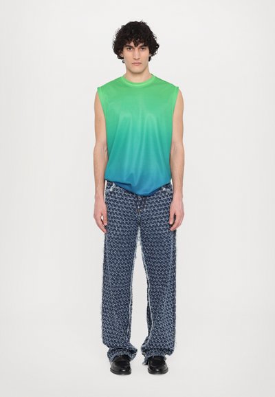 Sleeveless gradient shirt transitioning from green to blue; textured patterned wide-leg pants; black footwear; minimal background.