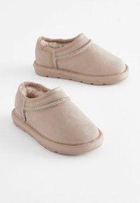 Ballerines beige clair en suède doux, avec une surface texturée, des coutures décoratives et une semelle en caoutchouc.