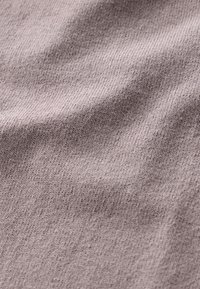 Textiel met textuur in een gedempt mauve kleur, met een fijne breipatroon en subtiele variaties, wat zorgt voor een zachte en gladde uitstraling.
