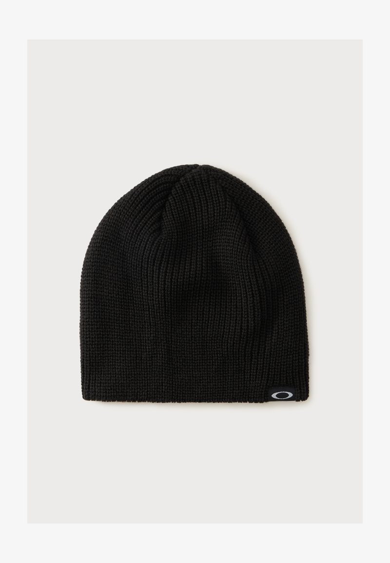 Bonnet en tricot noir avec une petite étiquette de logo noire et blanche sur le bord inférieur, sur un fond clair uni.
